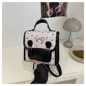 Détail du sac à dos rose à motif nœuds avec texture plissée et accents en cuir noir