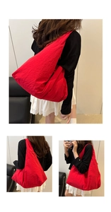 Detail of red oversized hobo tote bag featuring minimalist pleated texture and zipper