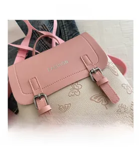 Close-up of pink and white PU leather backpack featuring embossed butterfly patterns