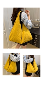 Detail of yellow large tote bag showing textured pleated fabric and side zipper pocket