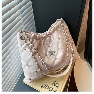 Close-up of beige quilted bucket bag with star rhinestone and elegant chain strap detail