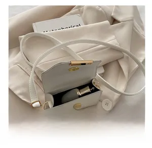 Detail view of cream white crossbody bag showing interior capacity with a lipstick