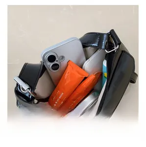 Internal view of black crescent underarm bag showing space for phone and cosmetics