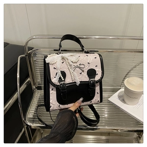 Détail du tissu jacquard floral avec nœuds en dentelle et chaînes de perles sur sac rose