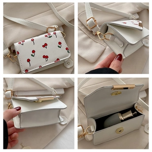 Detail of mini white cherry crossbody bag with gold hardware and interior view