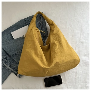 Close-up of yellow oversized tote bag with wrinkled nylon texture and leisure lifestyle vibes