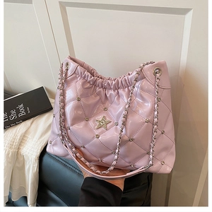 Detail of light pink quilted bucket bag with star metal buckle and shiny chain strap