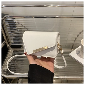 Detail of white cherry print handbag with golden metal trim and sleek PU leather texture