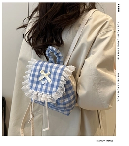 Detail of blue plaid backpack with lace trim and bow knot on sweet ruffled school bag