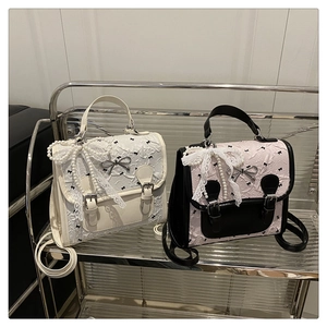 Détail du tissu gaufré à motif nœud et breloque en dentelle de perles sur des sacs