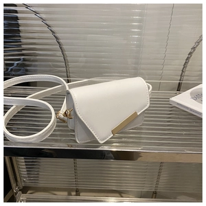Detailed view of mini white leather crossbody bag with minimalist gold metal buckle closure