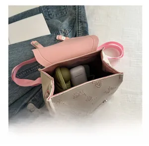 Internal view of mini embossed backpack showing storage for umbrella and earbuds