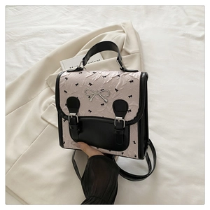 Détail d'un sac à dos beige rétro avec bordure noire et boucle en métal argenté