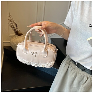Dettaglio borsa Boston rosa chiaro con fiocco argento e bordo in pizzo bianco