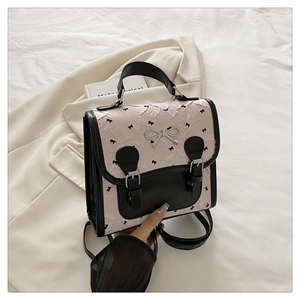 Détail du sac à dos texturé rose clair avec bretelles noires et boucle nœud en métal