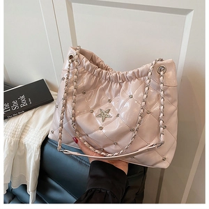 Detail of pink quilted bucket bag with star ornament and drawstring chain strap