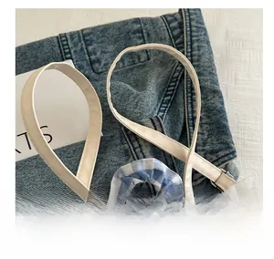 Detailed macro view of white adjustable faux leather shoulder strap on blue plaid lace bag