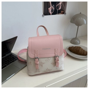 Detailed view of pink and white faux leather backpack with embossed butterfly patterns