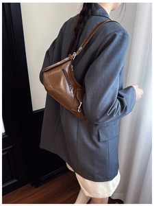 Detail of vintage brown faux leather hobo bag with silver zipper and metallic strap rings