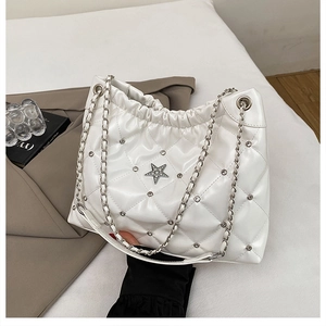 Detail of white quilted bucket bag featuring a diamond pattern and crystal star logo