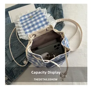 Internal capacity of blue plaid drawstring backpack showing storage for phone and perfume