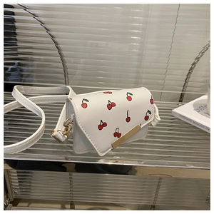 Close-up of white mini square crossbody bag with cherry prints and gold metal hardware