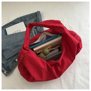 Red nylon tote bag interior showing large capacity for books and tablet device