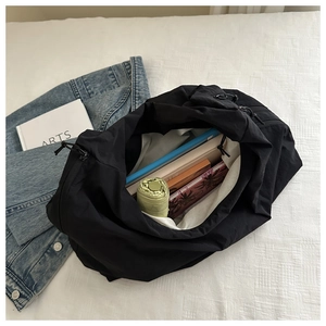 Internal view of black nylon tote bag showing spacious capacity for books and umbrella