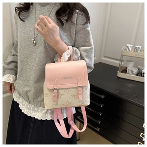 Close-up of pink and cream mini backpack with butterfly pattern and FASHION logo