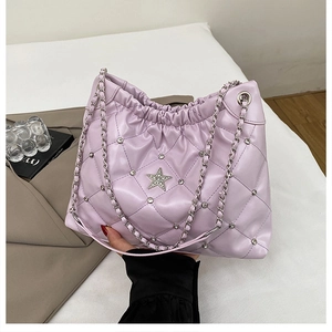 Detail view of purple quilted bucket bag with star accent and rhinestone stitching