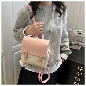 Detail of pink and beige mini backpack with butterfly prints worn as a crossbody bag