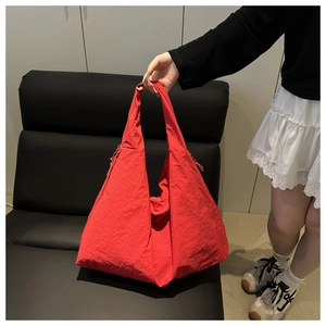 Macro view of a red tote bag featuring unique pleated nylon fabric and drawstring detail