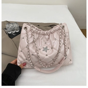 Detail of quilted beige tote bag with star rhinestone logo and silver chain strap