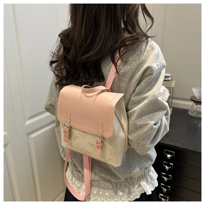 Detail view of pink and white floral backpack showing FASHION logo and butterfly prints