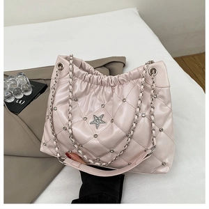 Detailed close-up of light pink quilted bucket bag with star charm and metallic studs