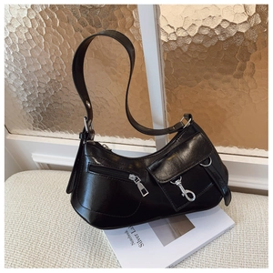 Detail view of a black glossy crescent moon shoulder bag with silver buckle and zipper