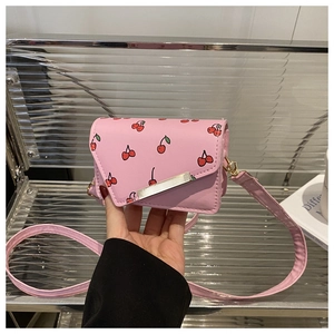 Detail of pink cherry print mini crossbody bag with silver metal bar and PU leather texture