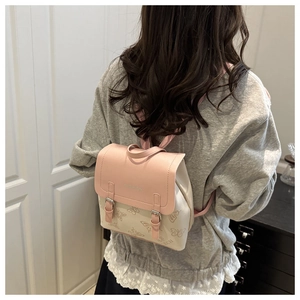 Close-up of pink flap and beige mini backpack with embossed butterfly details