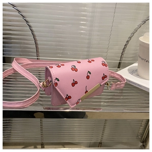 Detailed close-up of pink cherry print crossbody bag with gold metal trim and flap detail