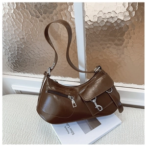 Detail of vintage brown leather underarm bag with silver buckles and zip pockets