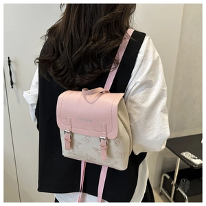 Close-up of stylish mini backpack with butterfly pattern and fashion logo metal detail