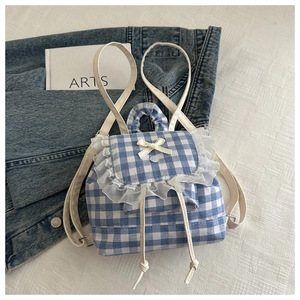 Detail of blue gingham mini backpack featuring delicate white lace trim and bow accent
