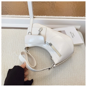 Detailed macro view of off-white crescent bag with silver hardware and moto-style zippers