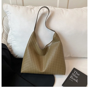Close-up of woven mesh texture and leather strap on olive green shoulder tote bag