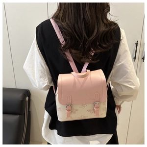 Detail of pink and white mini backpack featuring butterfly patterns and Fashion engraving