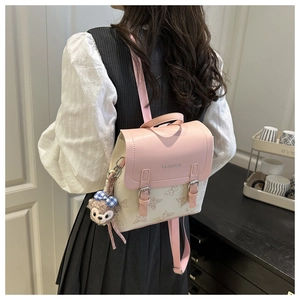 Close-up of pink and beige patchwork backpack with butterfly print and fuzzy bear charm