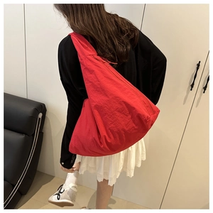 Close-up of a large red hobo shoulder bag showing its spacious design and vibrant fabric
