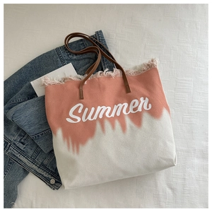 Close-up of pink and white canvas tote bag featuring Summer text and fringe detail