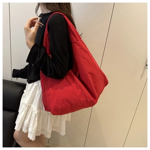 Red large capacity tote bag with natural texture shown on a female model for daily casual style