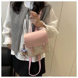 Close-up of pink and beige PU leather backpack featuring butterfly prints and metal buckles